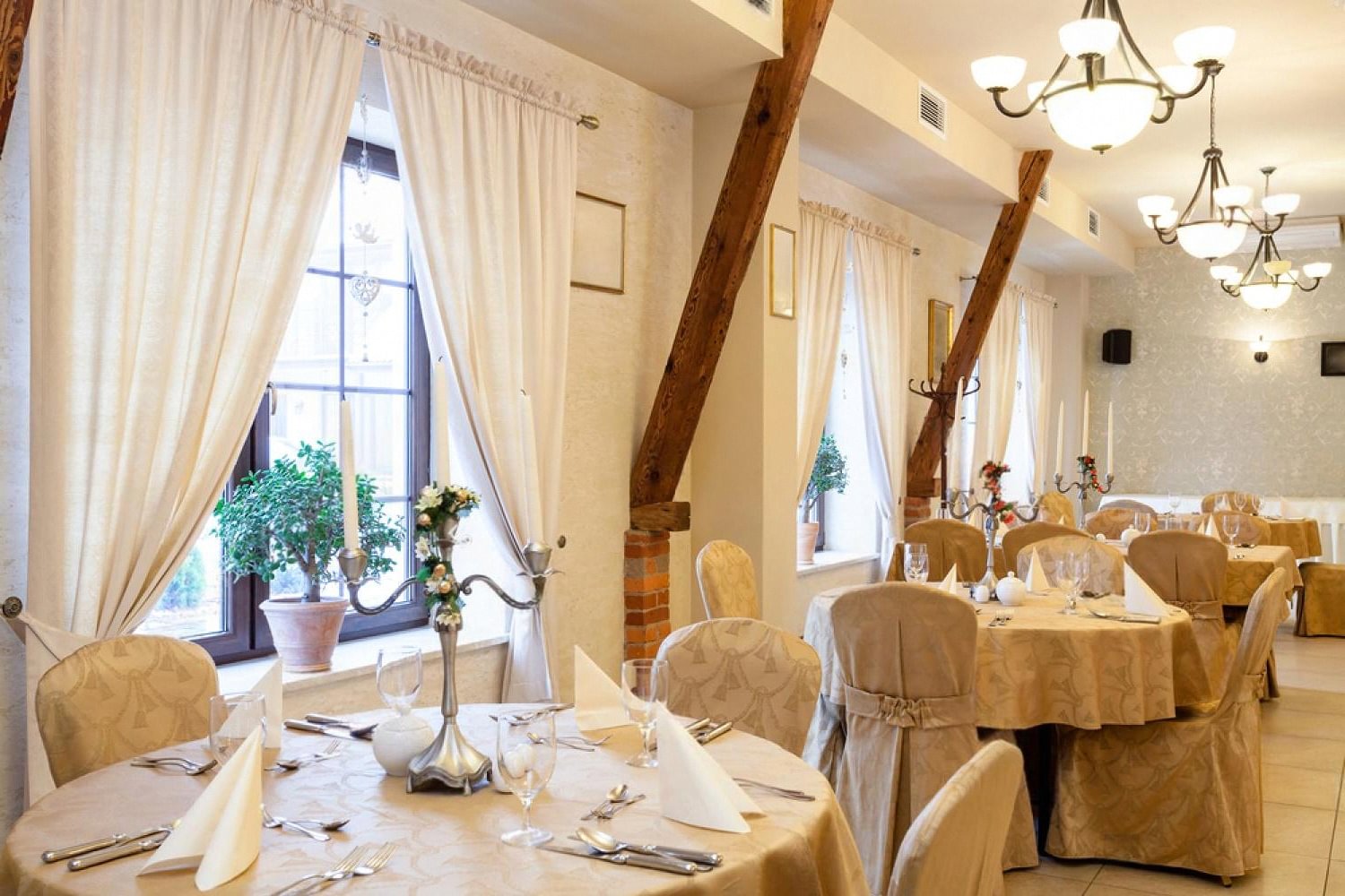 Elegant reception hall set with round tables, chair covers and candelabras for a luxury wedding